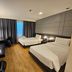 The Park Residence Bangkok room with two beds, desk, and dark curtains