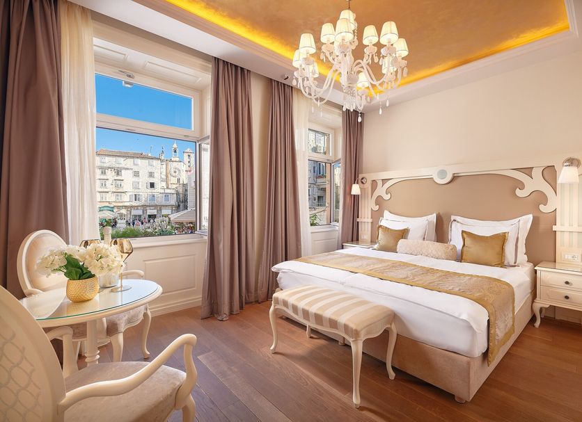 Piazza Heritage Hotel Split guest room with chandelier, king bed, bench, and city view windows