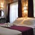 Olea Leya Hotel in Ayvalik, room with made bed, burgundy accents, and tall windows