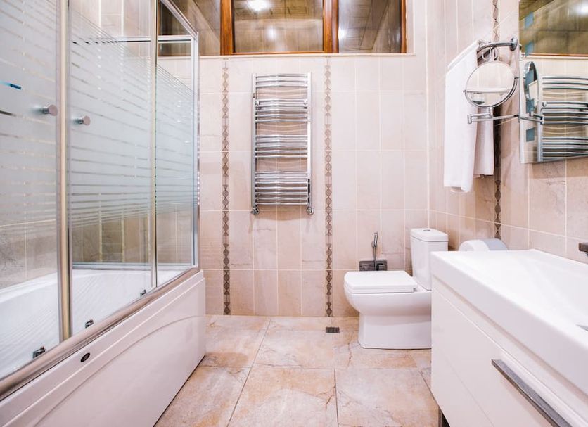 Admiral Hotel Baku bathroom with bathtub, glass shower, toilet and vanity
