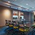 Aloft Waco Downtown meeting room with conference table, swivel chairs, and wall-mounted TV in Waco