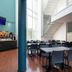 Kyriad Eco Lille Sud - Noyelles Godault lobby dining area with tall windows, stairs and blue columns