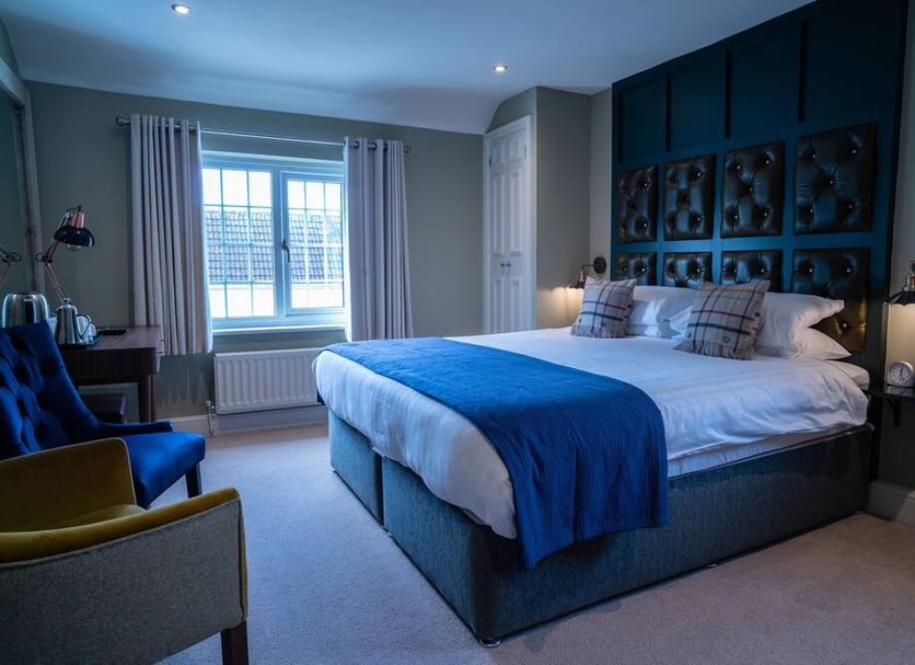 The Carpenters Arms Bristol guest room with king bed, window, and blue accent wall