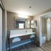 Hampton Inn and Suites Jamestown bathroom with vanity, mirror, and toilet-shower area