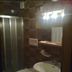 Borcanela Apartments in Moena bathroom with shower, toilet, sink, and mirror