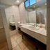 Hotel Casa del Sol in Managua bathroom with double sink, large mirror, tiled walls, and window