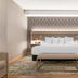 Radisson Plaza Hotel at Kalamazoo Center guest room with king bed and bench in Kalamazoo, MI
