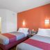 Motel 6 Junction City, KS guest room with two beds and orange accent wall