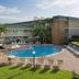 Ocean Breeze Inn Vero Beach pool deck with palm trees, lounge chairs, and hotel building in Vero Beach