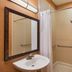 The Q Hotel & Suites Springfield bathroom with sink, mirror, shower, and toilet