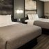 Super 8 by Wyndham Higginsville guest room with two beds and a window view in Higginsville