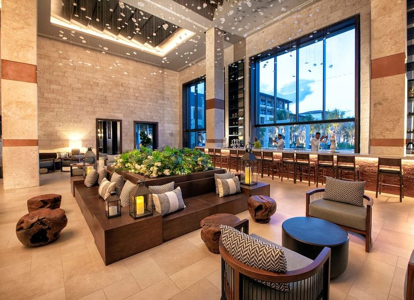 Unique Club at Lopesan Costa Bávaro Resort lobby in Punta Cana with floor-to-ceiling windows and lounge seating