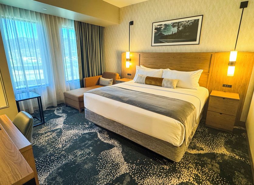 Rain Rock Casino Resort Hotel in Yreka guest room with king bed, sofa, and window view