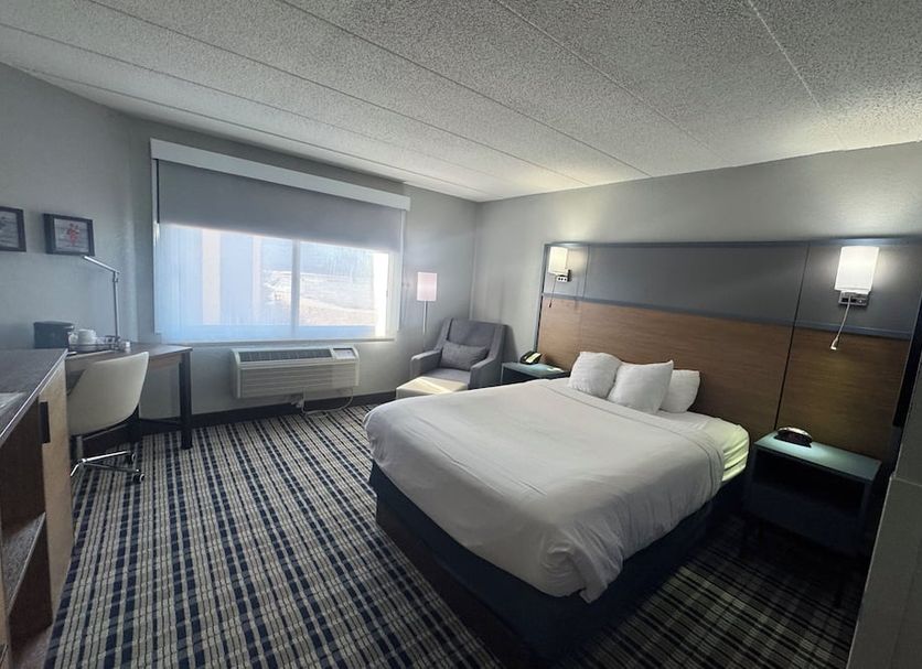 AmericInn by Wyndham Albert Lea guest room with king bed, desk, chair and window view