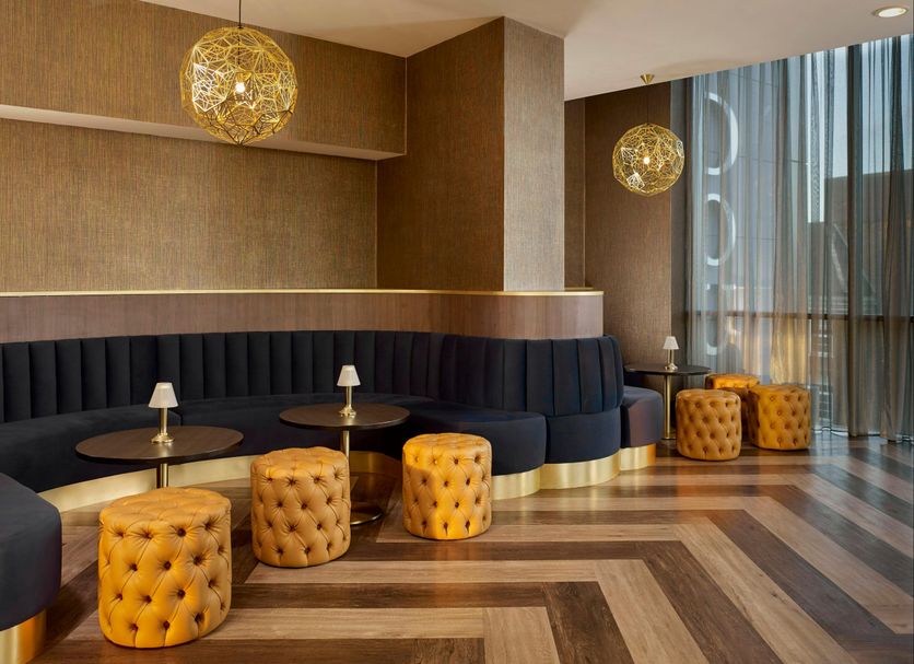 DoubleTree by Hilton Hull lounge seating with curved banquette, tufted stools and pendant lights