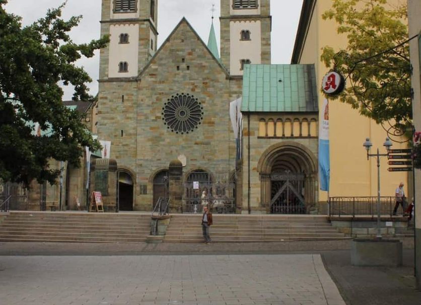 Stadt-Hotel Bartels in Werl with a stone church facade, twin towers, and steps in the foreground