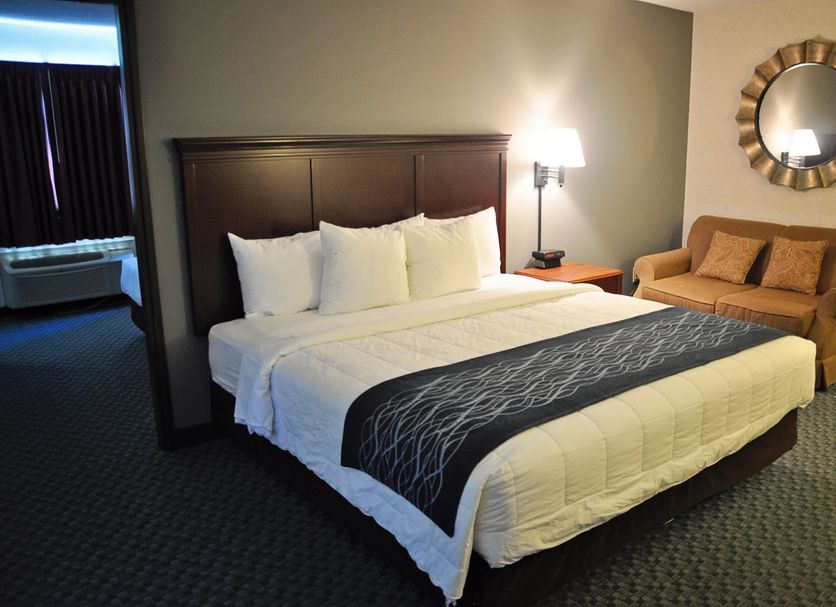 Dunes Express Inn and Suites in Hart guest room with king bed, sofa, lamp and wall mirror