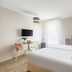 Appart'City Classic Reims Parc des Expositions guest room with twin beds, TV and table in Reims