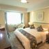 Jinshan Hotel Shanghai guest room with king bed, desk, armchair and window view