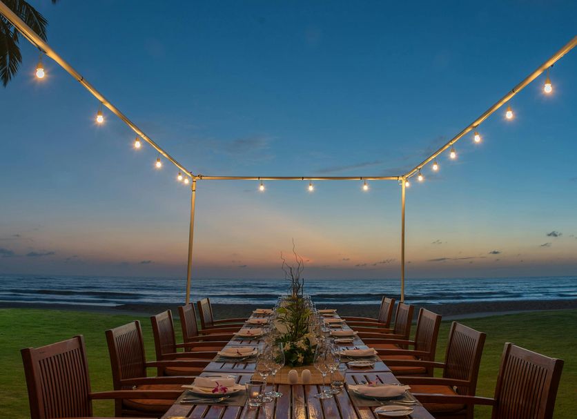 JW Marriott Khao Lak Resort & Spa in Takua Pa: beachfront dining table under string lights at sunset