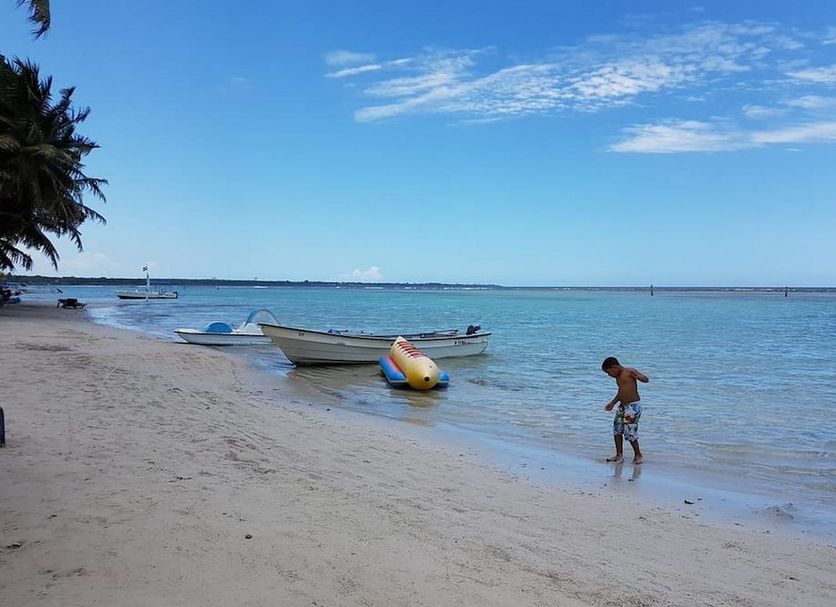 Hotel Costa Linda Beach Boca Chica beach view with boats and a child at the shoreline in Boca Chica