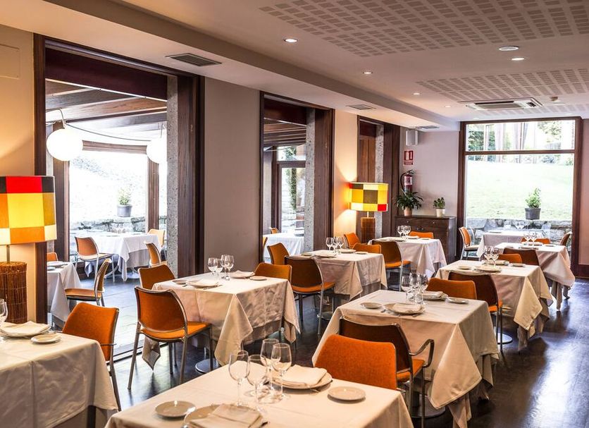 Hotel Rio Bidasoa restaurant in Hondarribia with set tables and bright window views