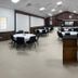 Super 8 Corsicana meeting room with round tables, black chairs, and a front podium