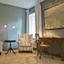 Hotel & Restaurant Gutshaus Ludorf in Bollewick guest room with striped armchairs, desk and map wall art
