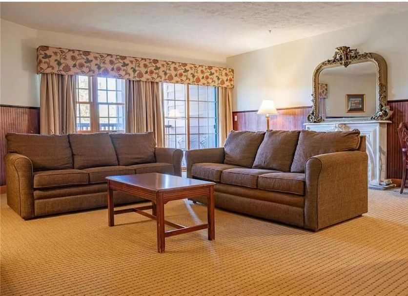 Hanah Mountain Resort And Country Club in Margaretville living room with sofa, coffee table and fireplace mirror
