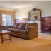 Hanah Mountain Resort And Country Club in Margaretville living room with sofa, coffee table and fireplace mirror