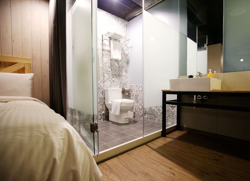 Nys Loft Hotel Taipei City room with glass-walled bathroom and toilet beside a bed