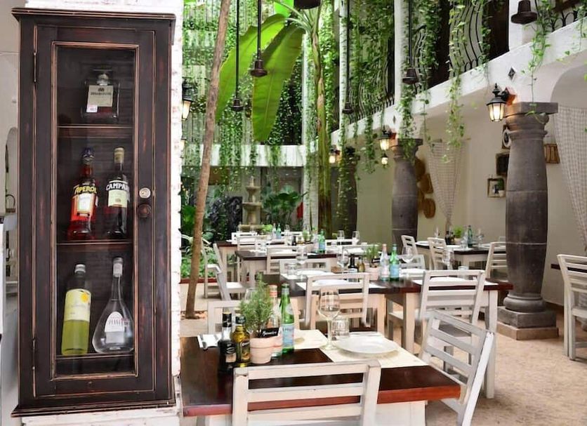 Unic Design Hotel in Playa del Carmen courtyard restaurant with hanging greenery and set dining tables