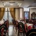 Rex Hotel Náfplio dining room with set tables, red chairs, and window drapes
