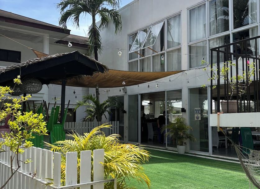 Seabird International Resort in Boracay with a courtyard, green lawn, hammock, and palm trees