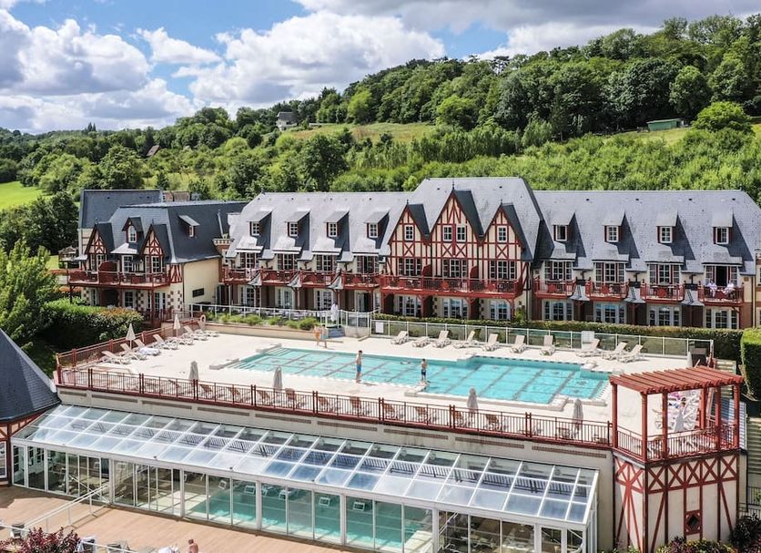 Pierre & Vacances Premium Residence & Spa Houlgate outdoor pool with hillside hotel buildings