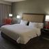 Hampton Inn Mcpherson guest room with king bed, armchair and window in McPherson