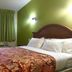 Red Carpet Inn - New Brunswick room with bed, green accent wall, and window with curtains