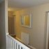 The Kings Head in Meifod hallway with white railing, wall mirror, radiator and wooden room door