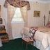 The Garden Walk Bed & Breakfast in Lookout Mountain bedroom with canopy bed, floral drapes, and window light