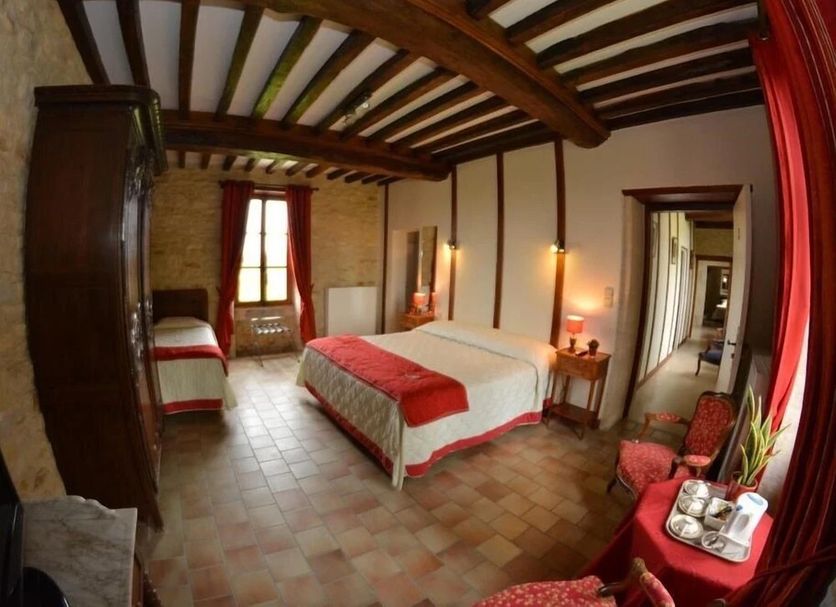La Ferme de la Gronde in Bayeux: rustic guest room with wood beams, bed, window and hallway view