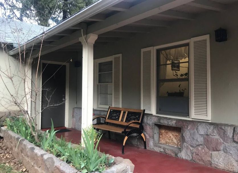 Dunsmuir Lodge in Dunsmuir: covered porch with bench, stone base and red floor
