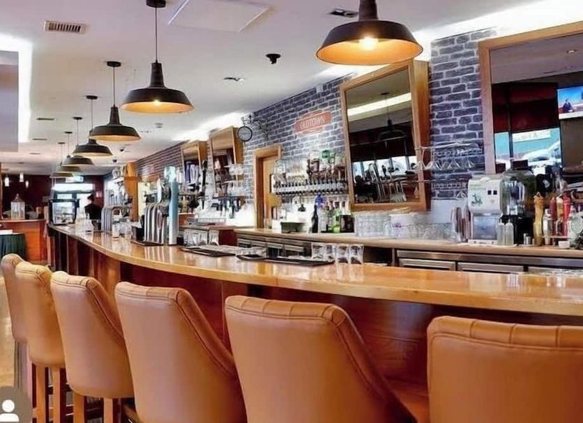 Station House Hotel Letterkenny bar with leather stools and brick-walled back bar