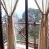 Oasis Tepoztlán in Tepoztlán, balcony view with curtains and treetops through glass doors