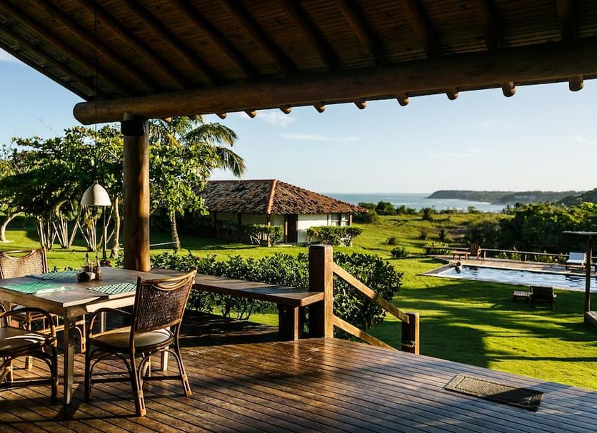 Pousada Outeiro in Trancoso with deck seating, lawn, pool and ocean view