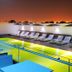 Hues Boutique Hotel Dubai rooftop pool with lounge chairs and city skyline at night
