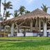 Mar Paraiso Queen in Acapulco: thatched palapa lounge pavilion on a grassy lawn with palm trees