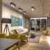 Downtown Apartments Mitte Berlin lounge with yellow chairs, sofa, coffee table and glass doors to balcony