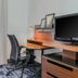 Fairfield Inn & Suites by Marriott Houston Westchase guest room with desk, chair and TV