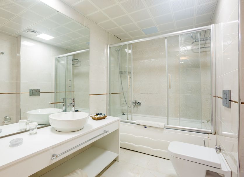 P Galata Hotel Istanbul bathroom with double sink vanity, mirror, bathtub and glass shower enclosure
