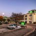 HomeTowne Studios by Red Roof Austin exterior with parking lot and lit guest rooms at dusk